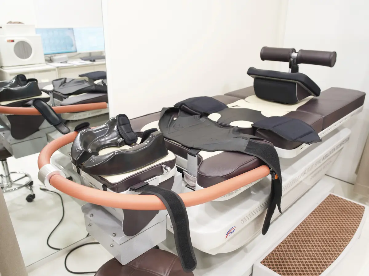 「SPINE MOBILIZATION DECOMPRESSION」 글자가 적힌 감압 치료 침대와 고정 벨트