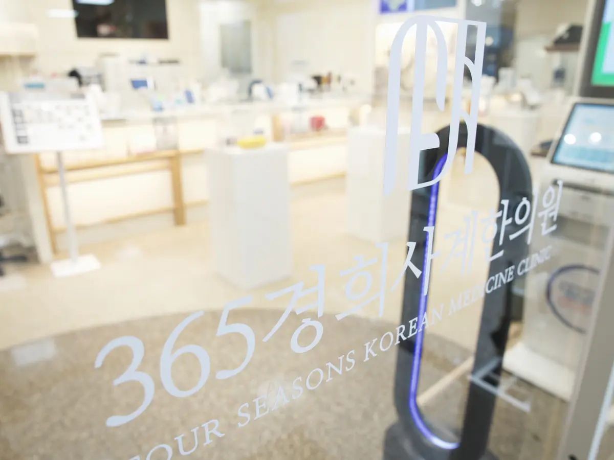 「365경희사계한의원」 글자가 적힌 출입문 유리 너머로 보이는 접수 공간